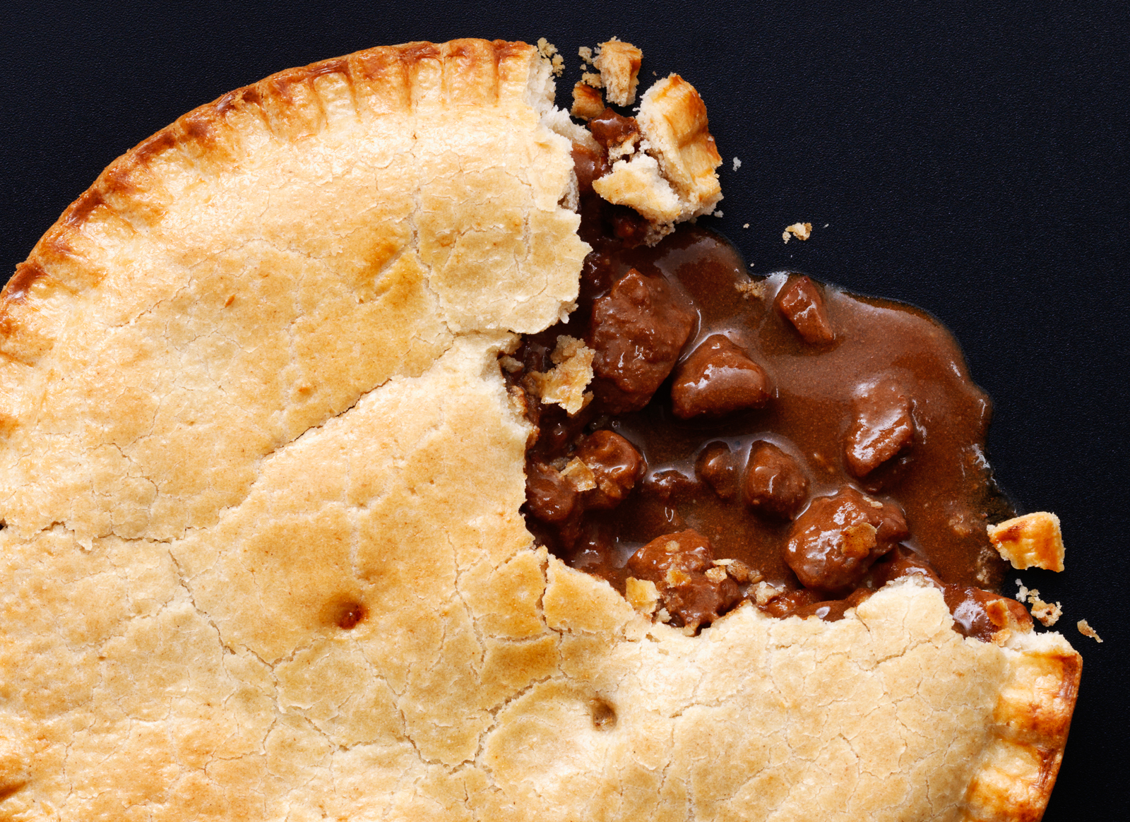 Photograph of whole meat pie with a slice taken out