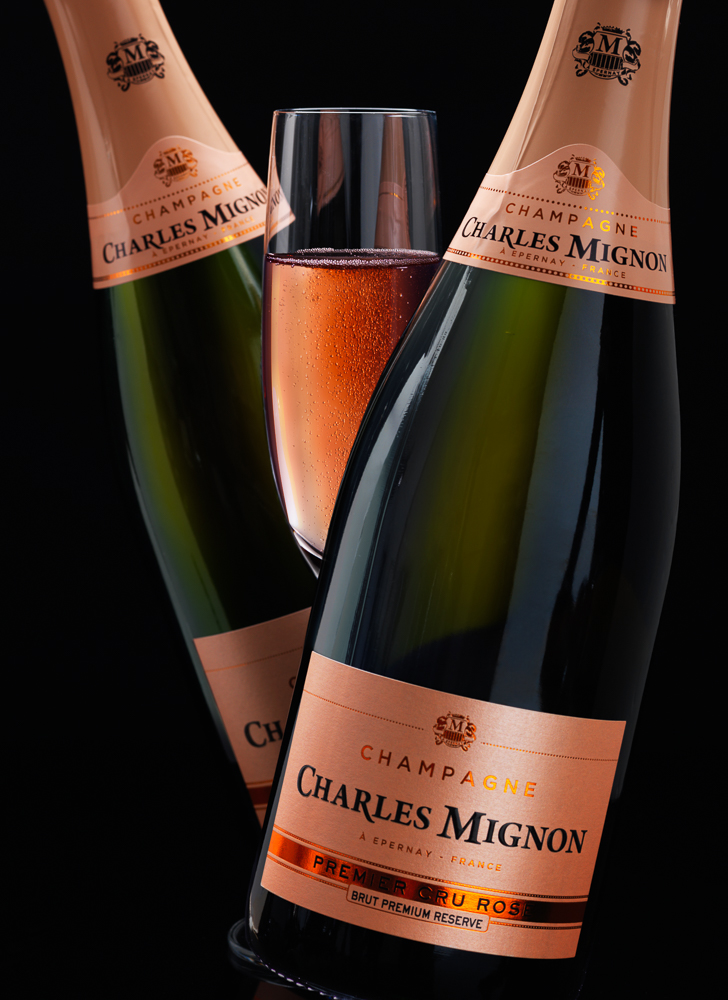 Photograph of two bottles of pink champagne with a glass of champagne