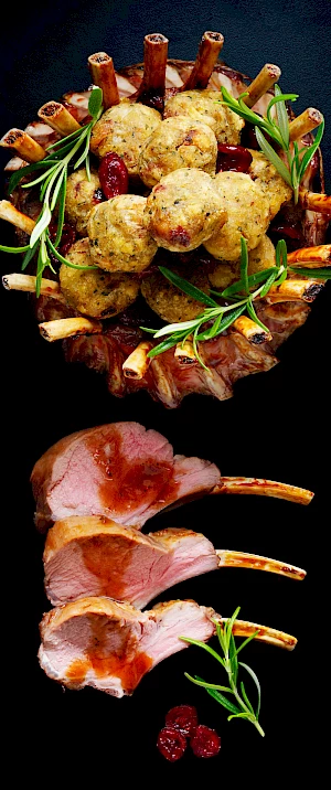 Photograph of a crown of lamb with stuffing balls and rosemary and slices of lamb with sauce