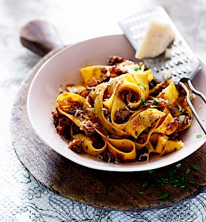 Photograph of Venison Pappardelle in a bowl with grated parmesan