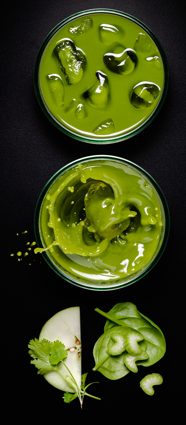 Photograph of glasses of apple, spinach and celery juice with an ice cube splash
