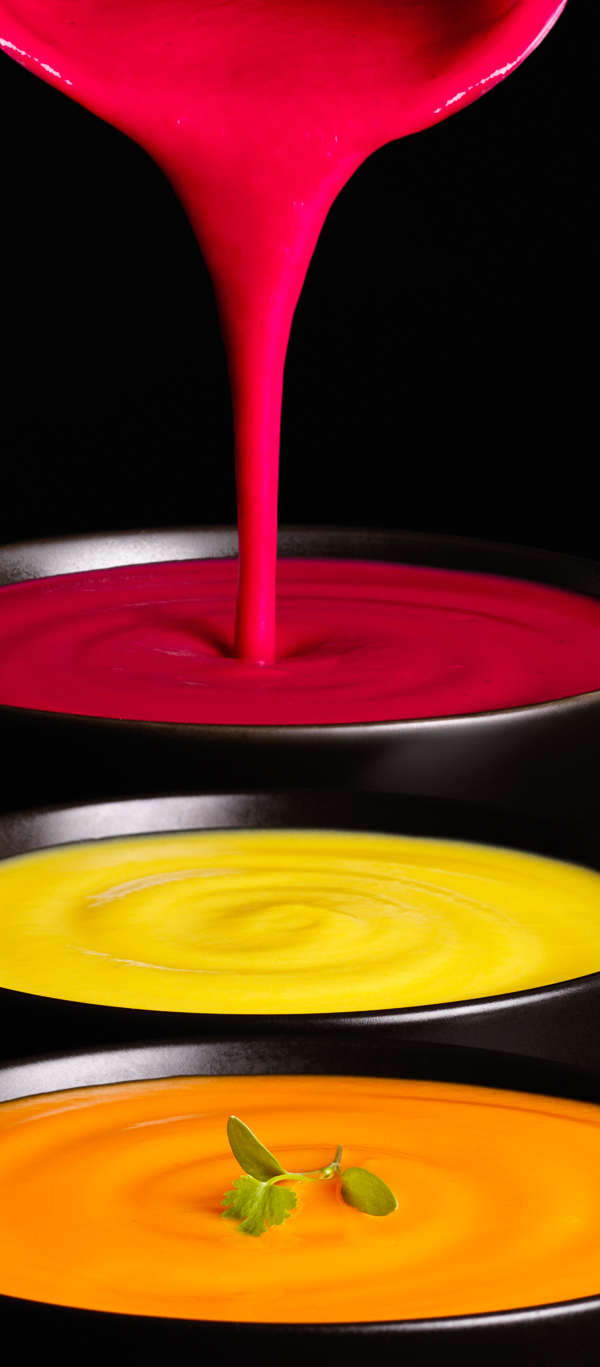 Photograph or bowls of soup with pan pouring liquid
