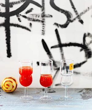 Photograph of a Red Pepper Bellini with a peeled orange and graffiti