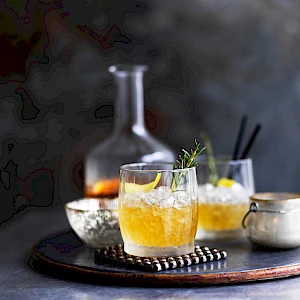 hotograph of a whiskey cocktails with rosemary and lemon, decanter