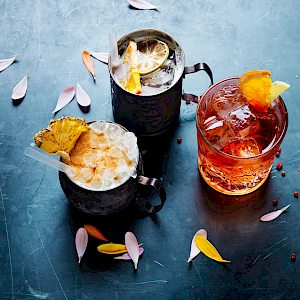 Photograph of three cocktails with petals