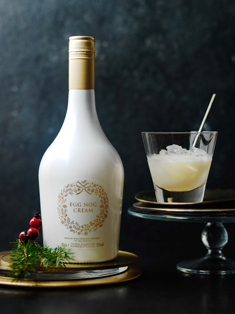 Photograph of glass of egg nog and bottle of egg nog cream