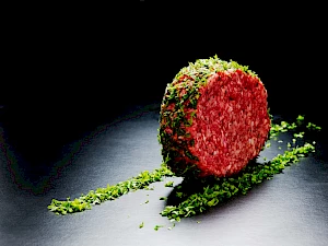 Raw Burger Patty Rolling In Herbs