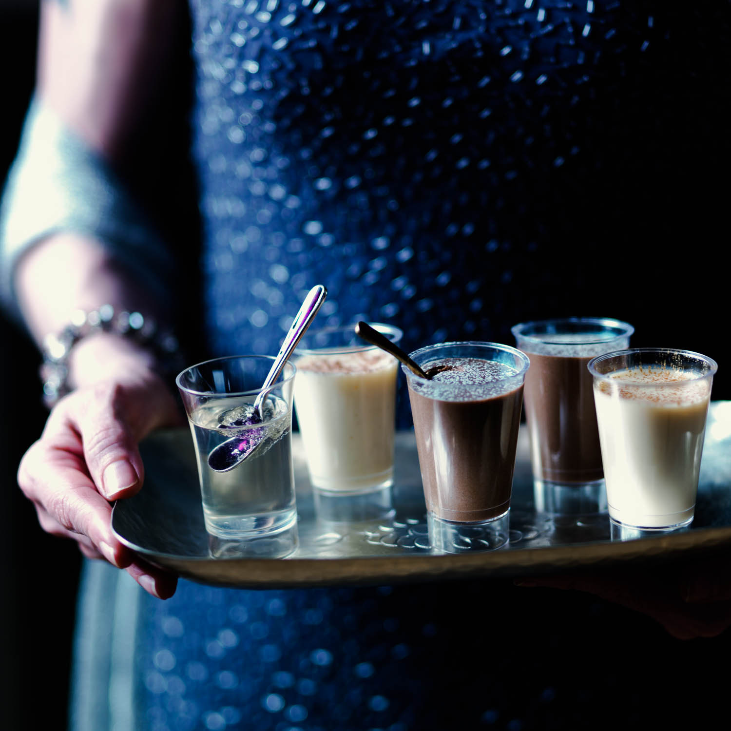 Hands holding Christmas Party Jellies and Mousse on Tray